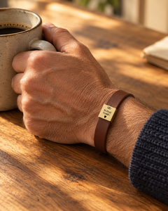 Bracelet marron porté au poignet, tasse de café sur une table