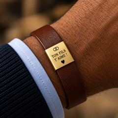 Bracelet marron avec plaque dorée « Ton fils t'aime » porté au poignet