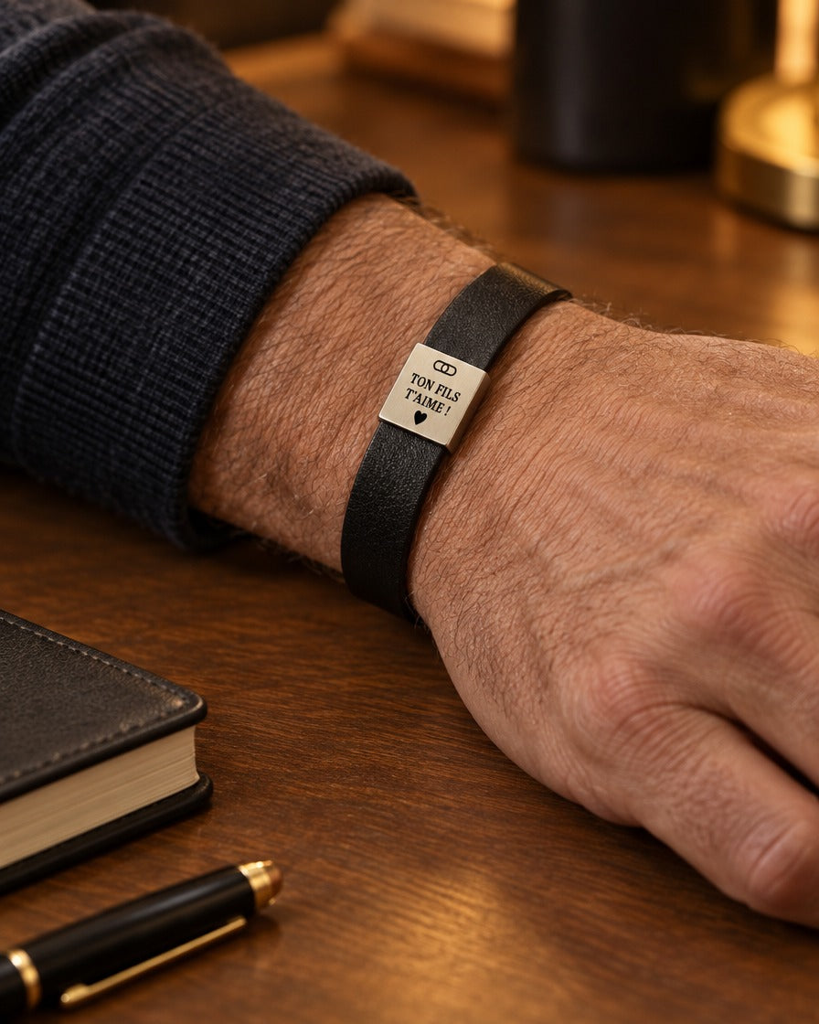 Bracelet noir avec plaque dorée porté au poignet